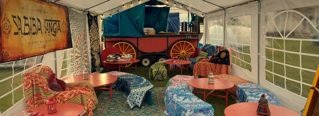 The Sababa Sangha lounge: a marquee with low benches, bright throws, lanterns and the food wagon